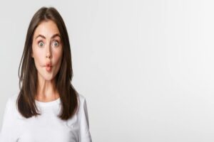 Closeup Of Funny And Cute Brunette Girl Suckink Lips Making Fish Grimace White Background 1